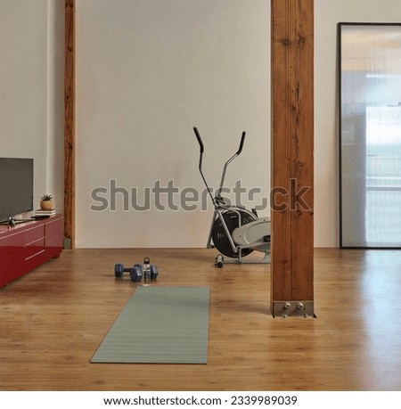 Doing sports at the chalet, mountain home, mat, dumbbell and bike. Wooden column and ceiling interior decor.
