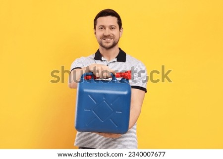Man holding blue canister on orange background