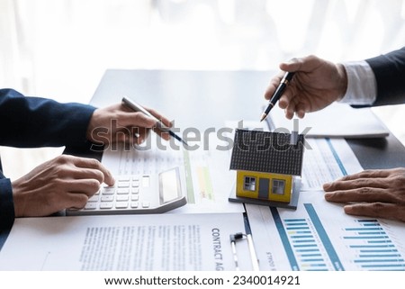 Successful real estate businessmen meeting to discuss company annual calculation profit in office