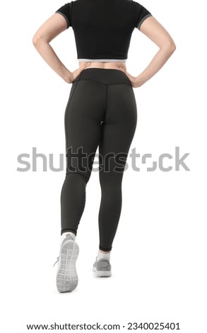 Young woman in sportswear on white background, back view
