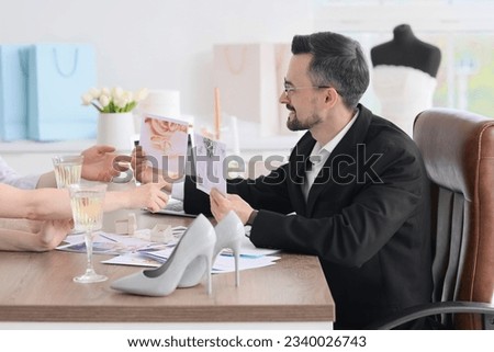 Male wedding planner working with couple in office
