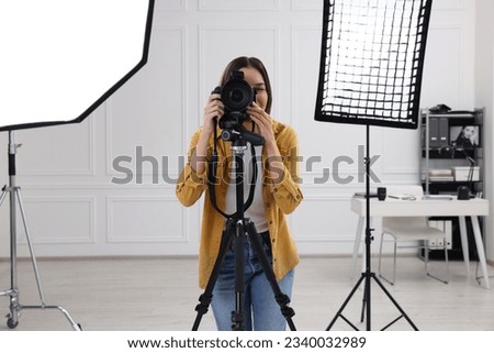 Professional photographer taking picture in modern photo studio