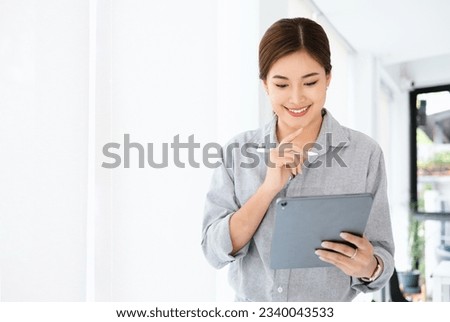 Thinking about how to take the business to technological heights. Smiling attractive cheerful young businesswoman working in modern office.