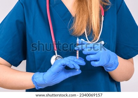 Nurse holding a syringe with a needle in her hands