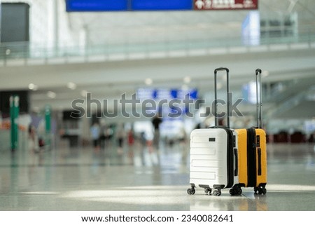 Two suitcases in an empty airport hall, traveler cases in the departure airport terminal waiting for the area, vacation concept, blank space for text message or design Royalty-Free Stock Photo #2340082641