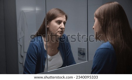 Upset woman standing at sink and thinking of her problems and depression. Concept of depression, stress, mental illness and problems, loneliness and frustration Royalty-Free Stock Photo #2340095333
