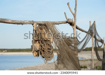 Close up of old fishing gear such as nets with a bay in the background at Fårö island Royalty-Free Stock Photo #2340095941
