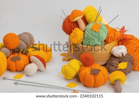 Set of clew of thread for knitting. Crocheted mushrooms, pumpkins, handmade, autumn hobby concept. Props and special craft tools on light stone concrete background, copy space Royalty-Free Stock Photo #2340102115