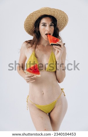 Slender athletic girl in summer swimsuit holds watermelon. Rest, vacation by sea