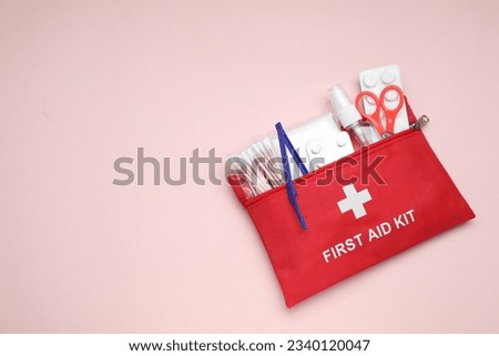 First aid kit on pink background, top view. Space for text