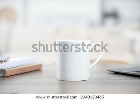White ceramic mug and notebooks on wooden table indoors. Space for text Royalty-Free Stock Photo #2340120465