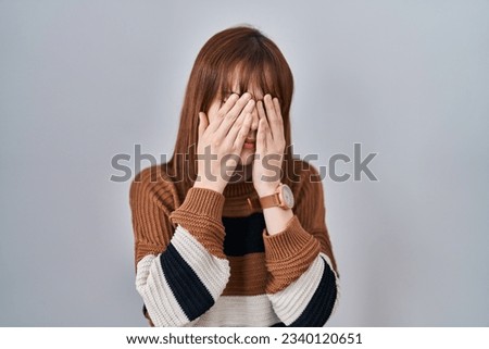 Young beautiful woman wearing striped sweater over isolated background rubbing eyes for fatigue and headache, sleepy and tired expression. vision problem 
