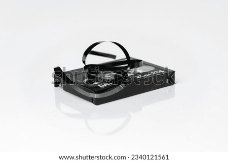 DAT (Digital Audio Tape) cassette with twisted tape isolated on white