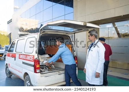 Doctor receiving old man from ambulance and checking while moaning in pain. Royalty-Free Stock Photo #2340124193