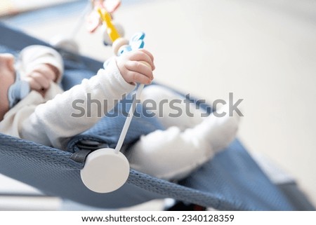 High angle view of unrecognizable baby playing in his rocking swing chair at home. Royalty-Free Stock Photo #2340128359