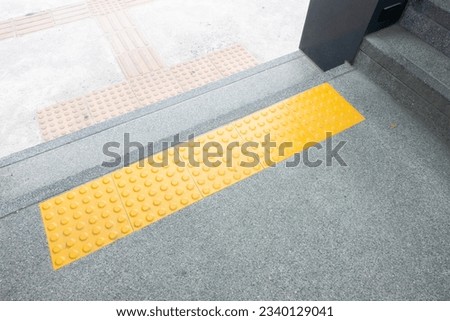 Bright yellow tactile paving for blind pedestrians on street or sidewalk,Guiding block for disability.
