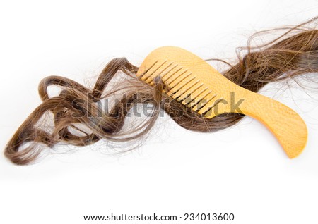 wooden comb brush with long hair, on white background
