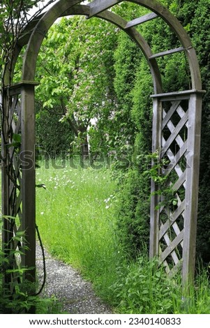 A wooden rose arch entrance to the garden