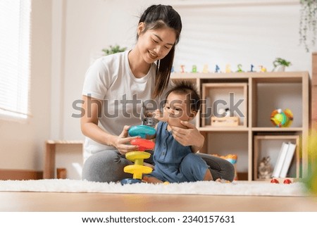 Asian mom teaching baby boy learning and playing toys for development skill at home or nursery room. Happiness mother and baby spending time together at warmth place. Good moment with mom and baby Royalty-Free Stock Photo #2340157631