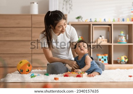 Asian mom teaching baby boy learning and playing toys for development skill at home or nursery room. Happiness mother and baby spending time together at warmth place. Good moment with mom and baby Royalty-Free Stock Photo #2340157635