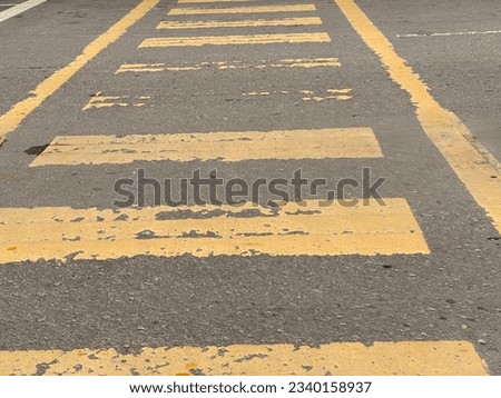 An asphalt road with a yellow zebra crossing.
