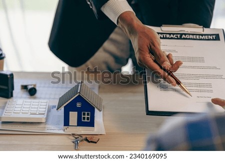 The concept of buying and selling real estate housing estates. The salesperson calculates the price and explains the details of the transaction to the customer and gives advice on bank loans.