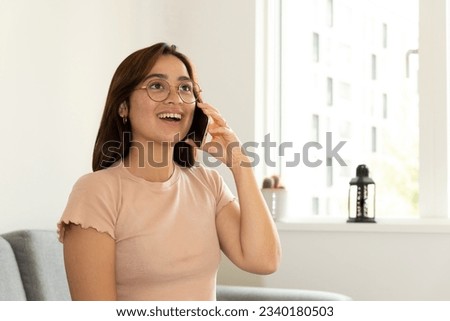 woman sitting in the living room of her home talking on the phone