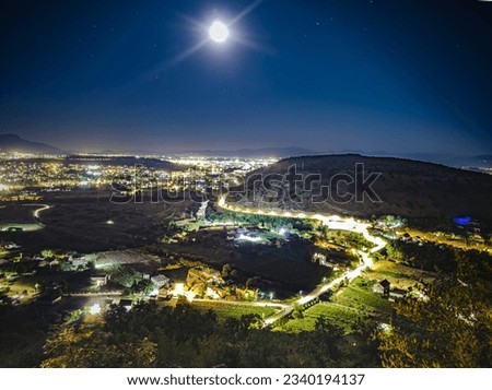 A night landscape of city of Podgorica lightened by the moon, taken from the nearby hill. It consists of 3 exposures merged into 1 HDR image using photo editing software. 