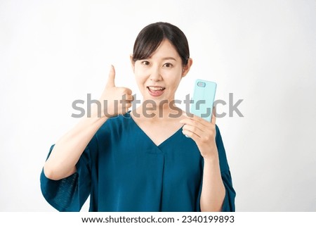 Asian middle aged woman with the smartphone thumbs up gesture in white back ground