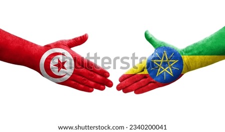 Handshake between Ethiopia and Tunisia flags painted on hands, isolated transparent image.