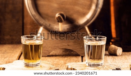 typical brazilian brandy glass, called "pinga" or "cachaça", made of sugar cane, rustic still setting Royalty-Free Stock Photo #2340201671