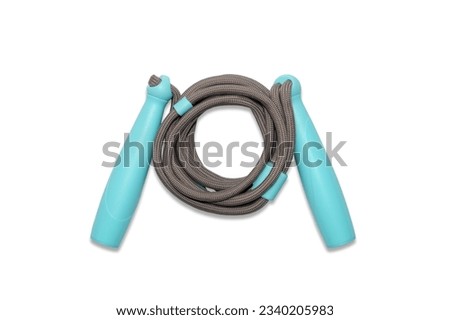 Sports jump rope isolated on white background. A gray children's jump rope with blue handles isolated on a white background. Royalty-Free Stock Photo #2340205983