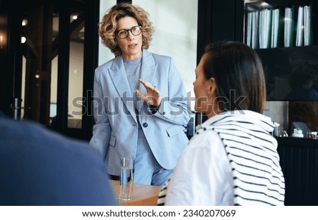 Professional woman leading a business meeting. Female manager planning a project with her colleagues. Business professionals working together in an office. Royalty-Free Stock Photo #2340207069