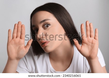 Shocked young woman stuck to transparent screen. Internet addiction