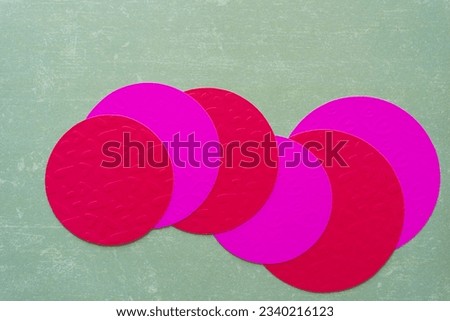 overlapping machine-cut embossed scrapbooking paper with hearts in hot pink and red on neutral green paper Royalty-Free Stock Photo #2340216123