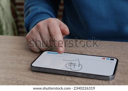 Electronic signature. Man using mobile phone at wooden table, closeup