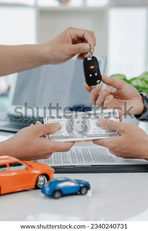 Car dealer calculates interest rates and car loan costs. Providing financial and insurance services While the customer reads the terms and conditions of the contract in the dealer's office.
