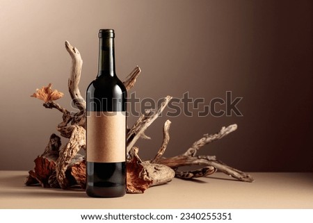 Bottle of red wine with a composition of old wood. Minimalistic composition on a beige background for product branding, identity, and packaging. Copy space. Royalty-Free Stock Photo #2340255351