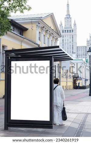 Vertical billboard at a public transport stop. The passenger is waiting for the bus. Mock-up.