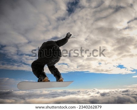 Snowboarder launching off a jump- horizontal orientation, daylight.