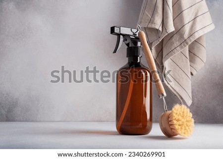 Single amber brown spray bottle and dish brush. Kitchen cleaning products for eco friendly and sustainable life style.  Royalty-Free Stock Photo #2340269901