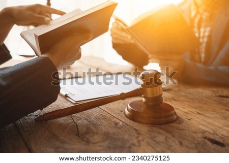 team of lawyers is reading legal revision of the law book to understand and learn the laws that affect their clients and will be able to advise clients who need legal advice. law book review concept Royalty-Free Stock Photo #2340275125