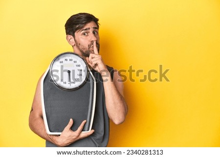 Athletic man with scale, on a yellow studio backdrop keeping a secret or asking for silence. Royalty-Free Stock Photo #2340281313
