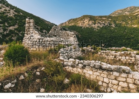 Ruins of ancient Illyrian fort Rizon, the oldest settlement in Boka Kotorska. Archeological site in Kotor Bay, remains of fortification above town of Risan. Travel Montenegro concept. Royalty-Free Stock Photo #2340306297
