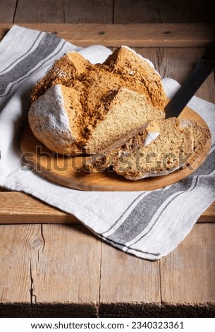 Traditional Irish soda bread made from whole grain and rye flour on a wooden table. Rustic style. Royalty-Free Stock Photo #2340323361