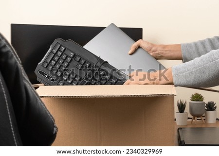 Woman hands put old laptop and keyboard in box with old used computers and gadget devices for recycling. Planned obsolescence, e-waste, donation, electronic waste for reuse, refurbish, recycle concept Royalty-Free Stock Photo #2340329969