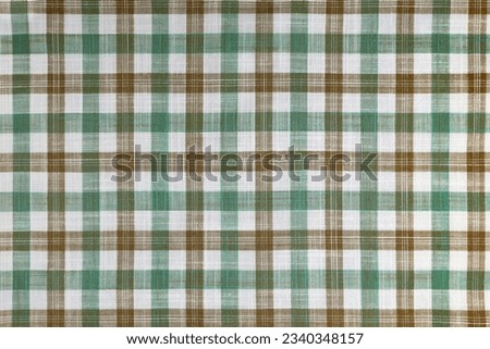 Green and brown checkered texture fabric, tartan pattern. Shirt fabric, tablecloth textile, linen plaid cloth, classic scottish check pattern. Backdrop, wallpaper, background. Royalty-Free Stock Photo #2340348157