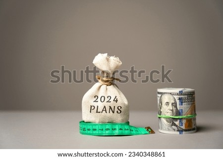 2024 plans concept. Setting goals and planning targets for the next year. Motivation, vision. Business and finance concept. Money bag and dollar bills Royalty-Free Stock Photo #2340348861