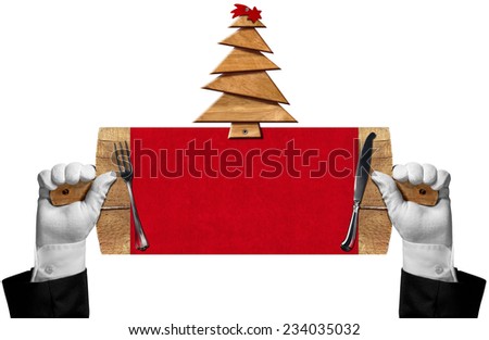 Two hands with white gloves holding a wooden signboard in the shape of a cutting board with wooden Christmas tree and red comet, silver cutlery. Template for a Christmas food menu
