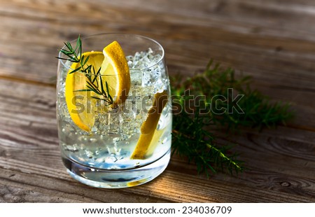 alcoholic drink with lemon and ice on a old wooden table Royalty-Free Stock Photo #234036709